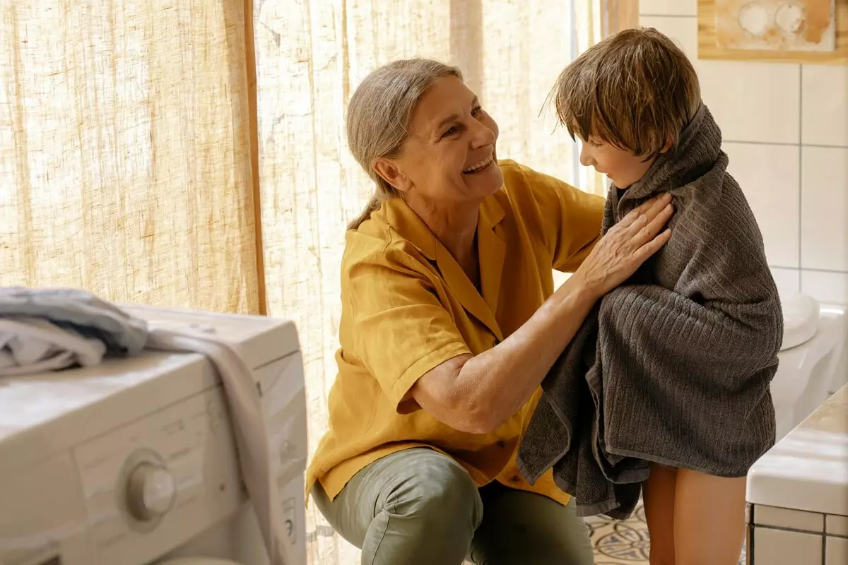 Mamma che asciuga un bambino nel bagno