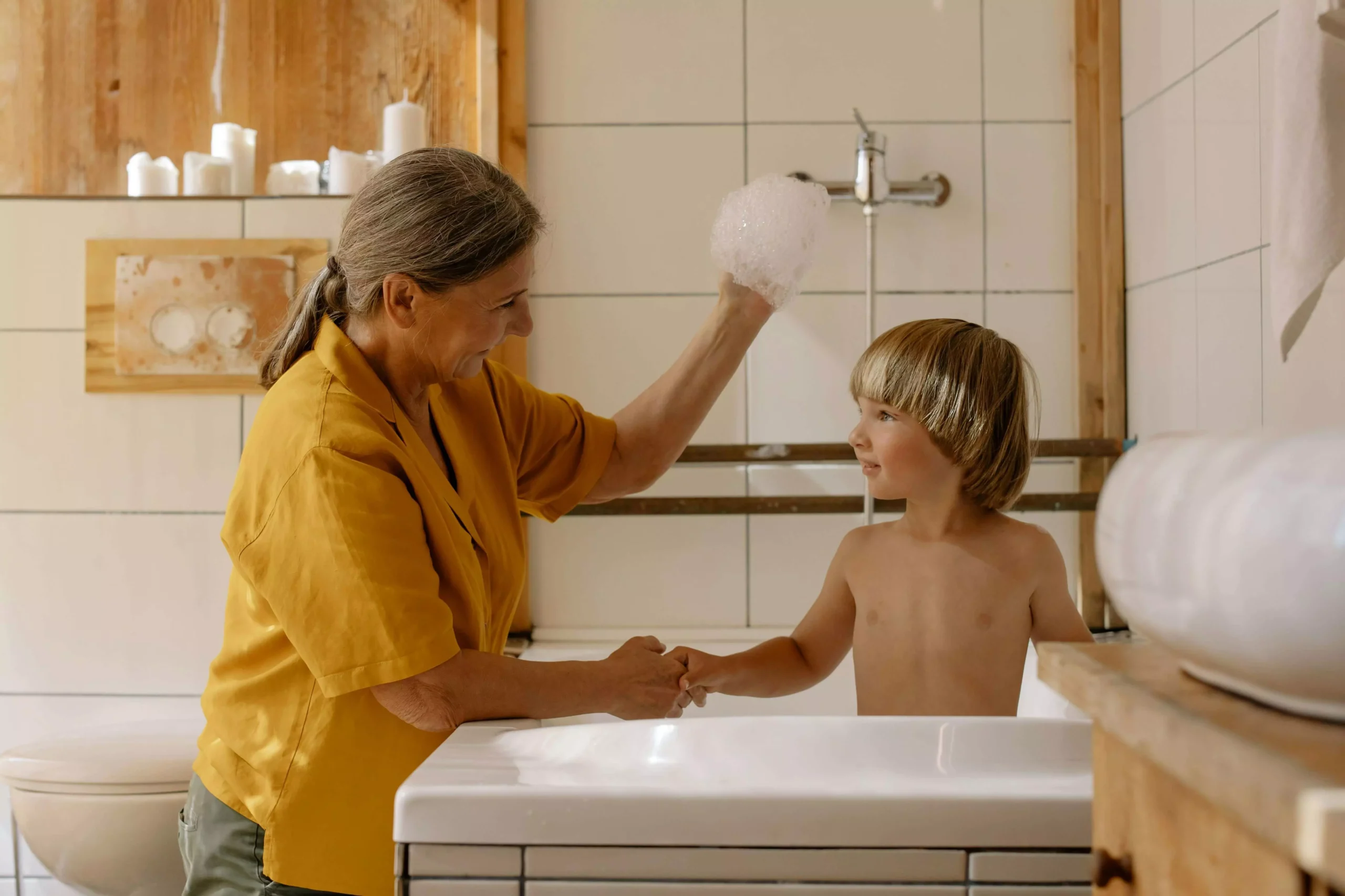 Nonna che gioca con suo nipote dentro ad una vasca da bagno