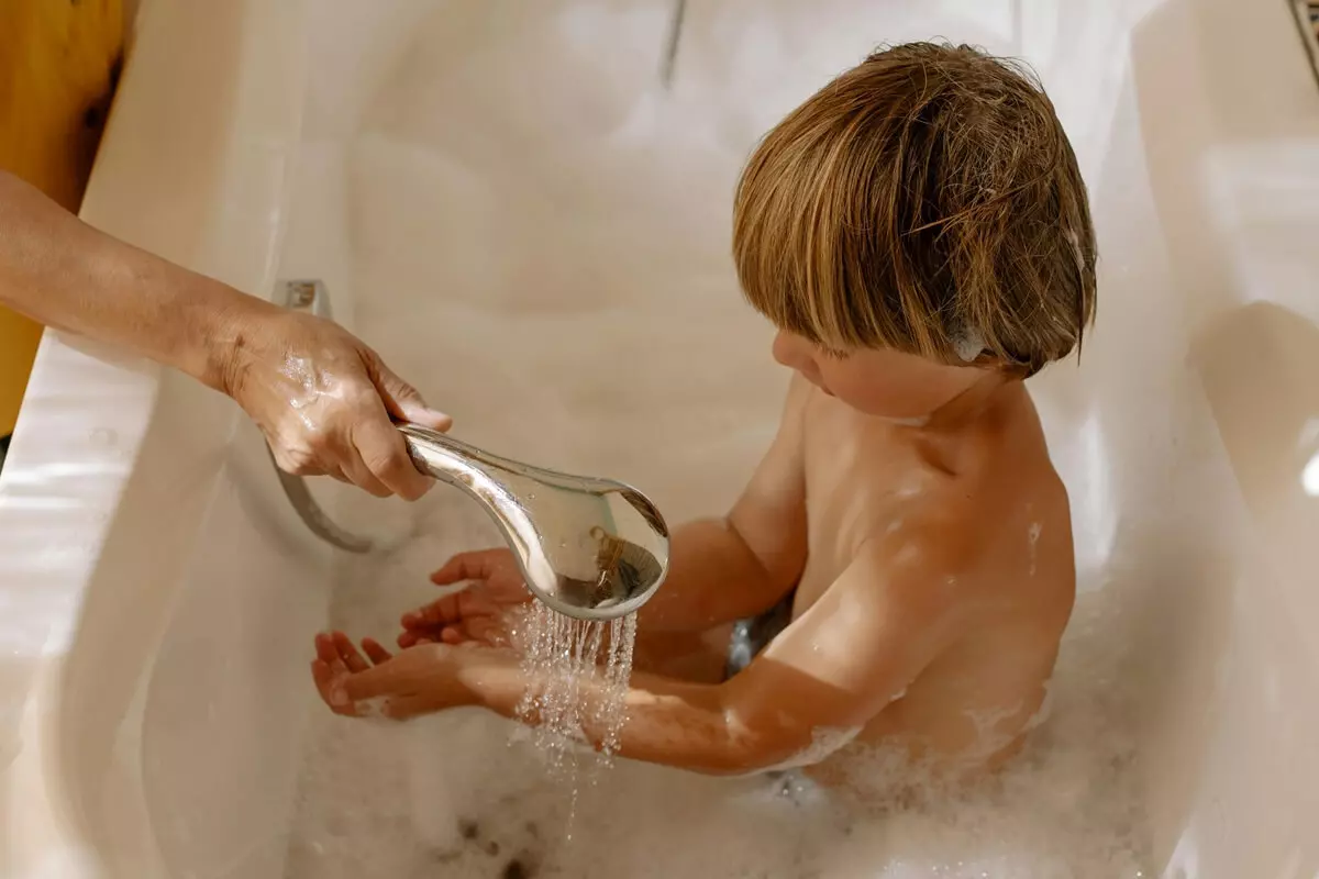 Bambino che gioca in una vasca da bagno 